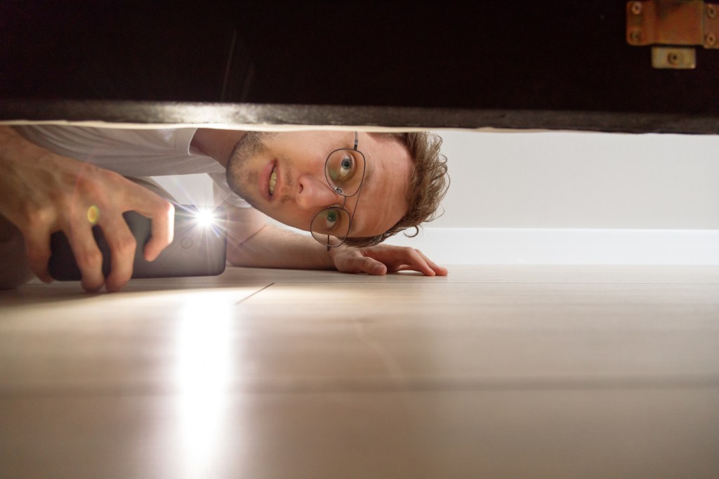 man looking under the bed